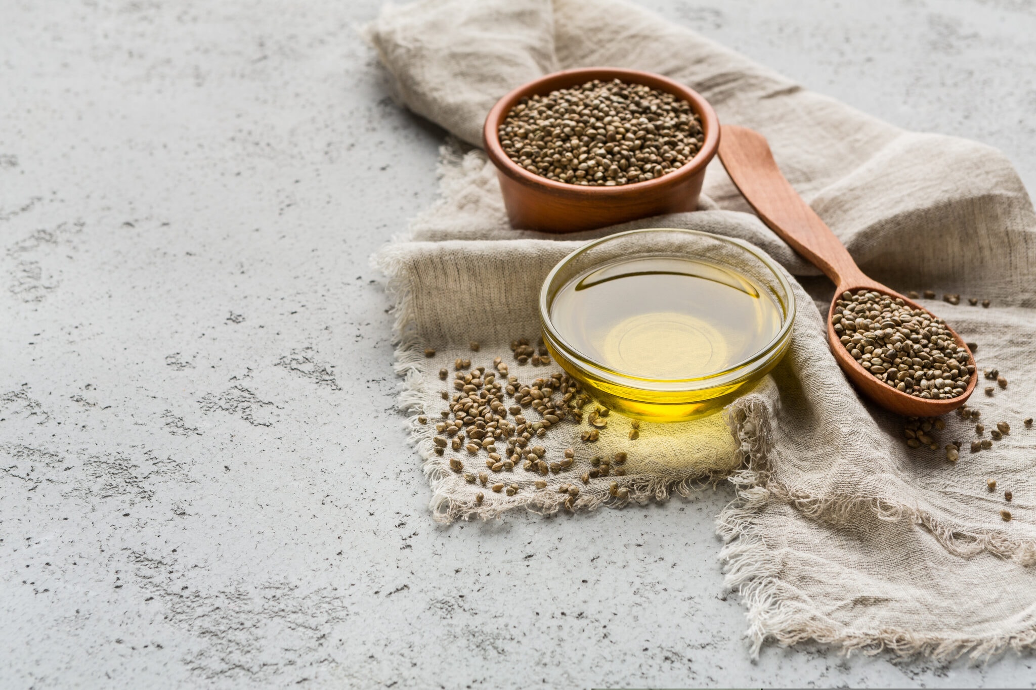 Hemp,Oil,And,Hemp,Seeds,In,Bowls,On,Concrete,Background.
