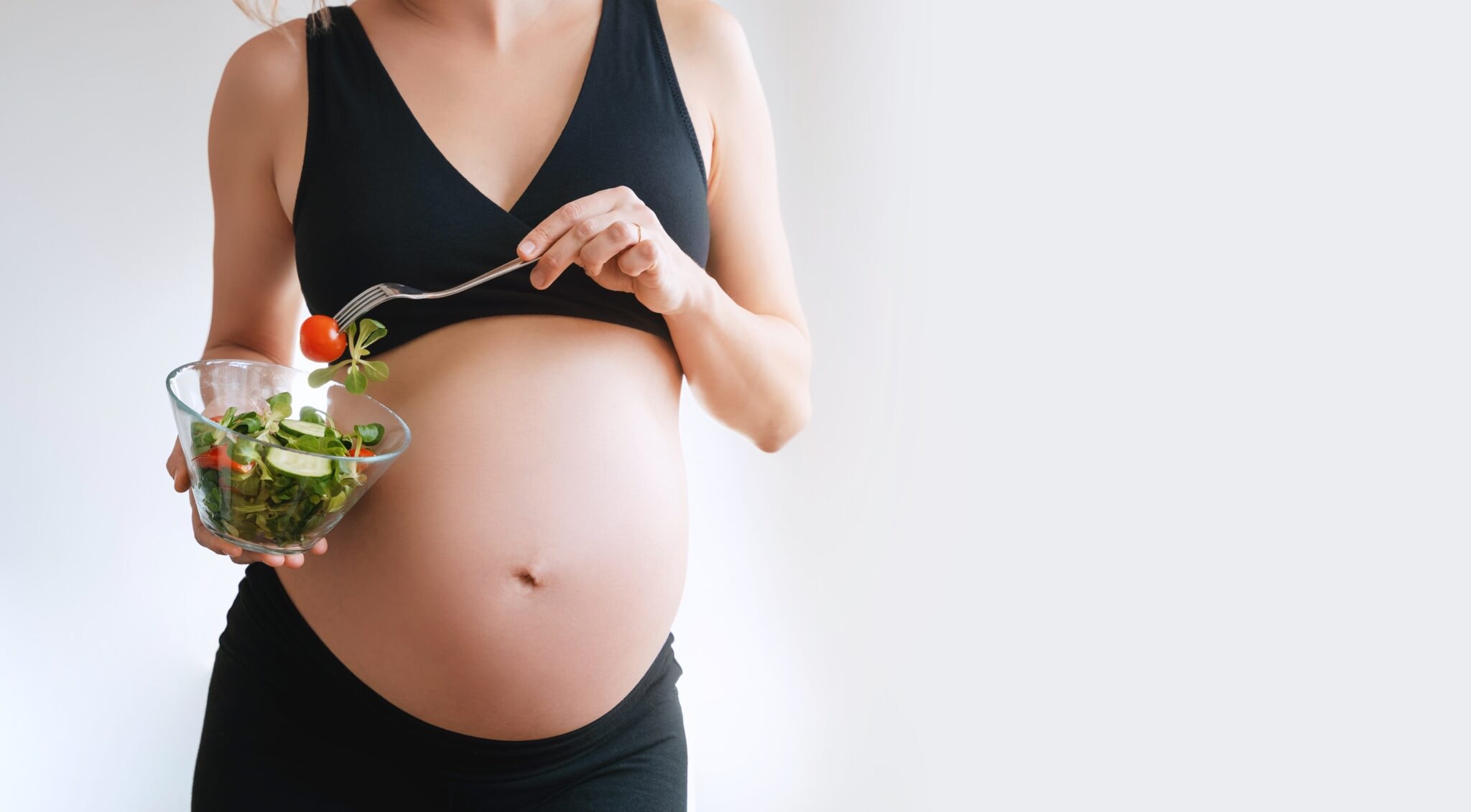 Pregnant,Woman's,Belly,And,Vegetable,Salad.,Pregnant,Woman,Eating,Healthy