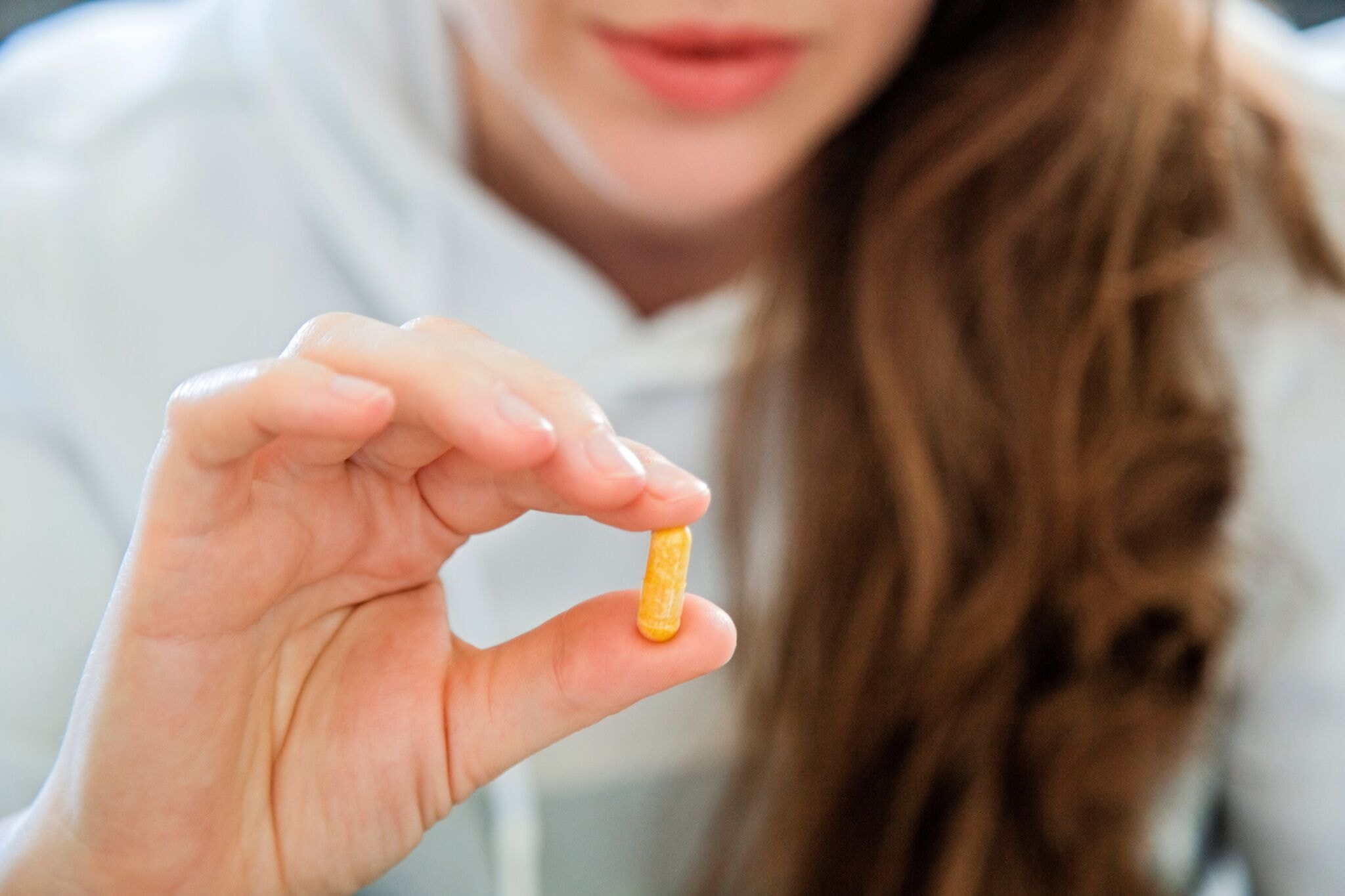 Close-up,Of,A,Young,Woman,Holding,A,Pill,Capsule,In