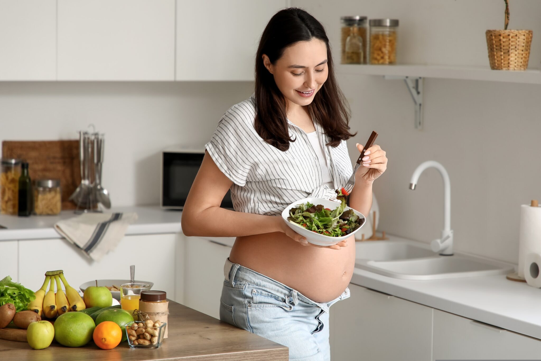 Young,Pregnant,Woman,With,Vegetable,Salad,In,Kitchen