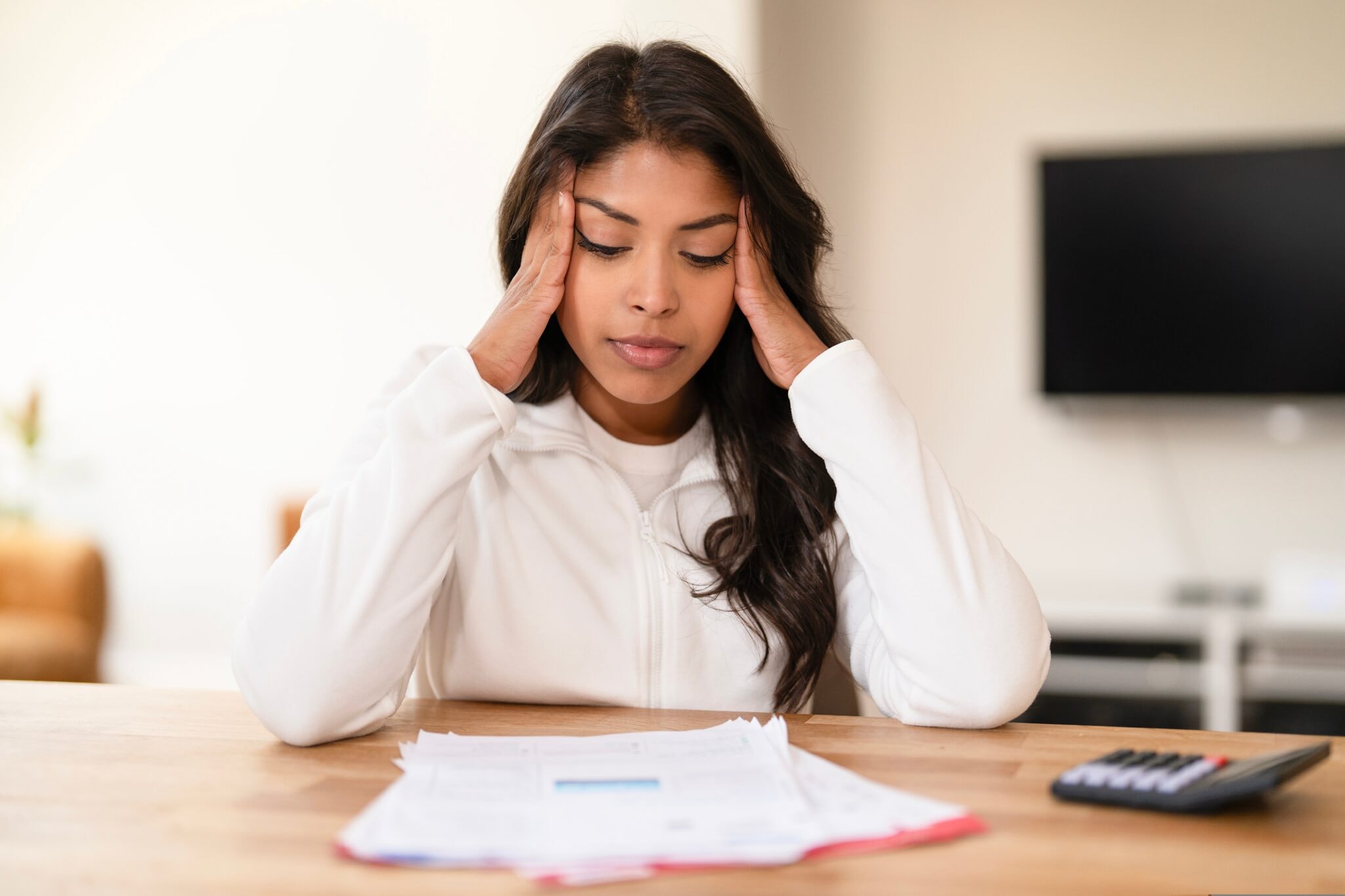 Young,Woman,Experiencing,Stress,While,Reviewing,Paperwork,In,A,Cozy